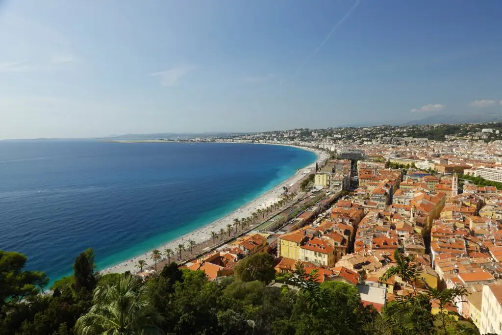 Panoramic view of Nice France with the Promenade des Anglais, Mediterranean coastline, and old town rooftops on a sunny day