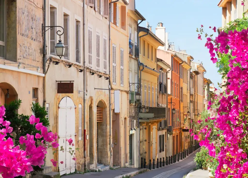 Colorful historic street with blooming flowers in Aix-en-Provence, France, showcasing traditional French architecture and charming buildings ideal for European private tours