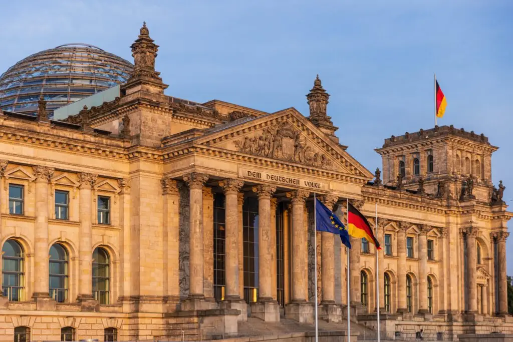 Reichstag building with glass dome and German flag in Berlin Germany, a famous historic landmark and popular tourist attraction