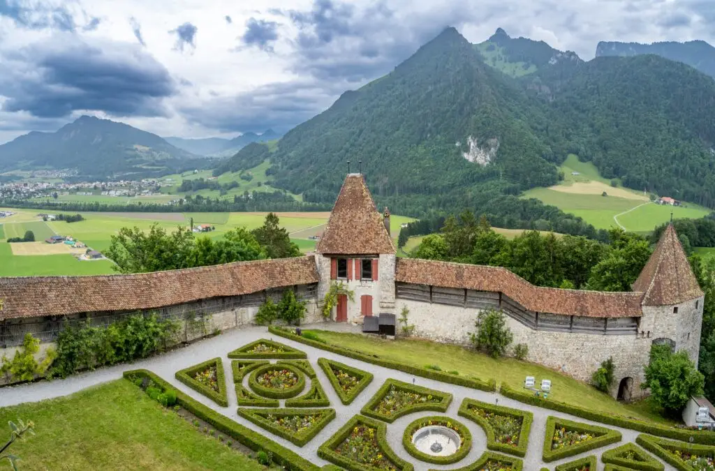 Medieval castle and gardens in Gruyères, Switzerland with panoramic view of the Swiss Alps and countryside