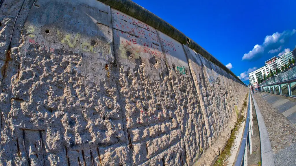 Historic Berlin Wall with weathered concrete and graffiti under blue sky, popular tourist attraction in Berlin Germany
