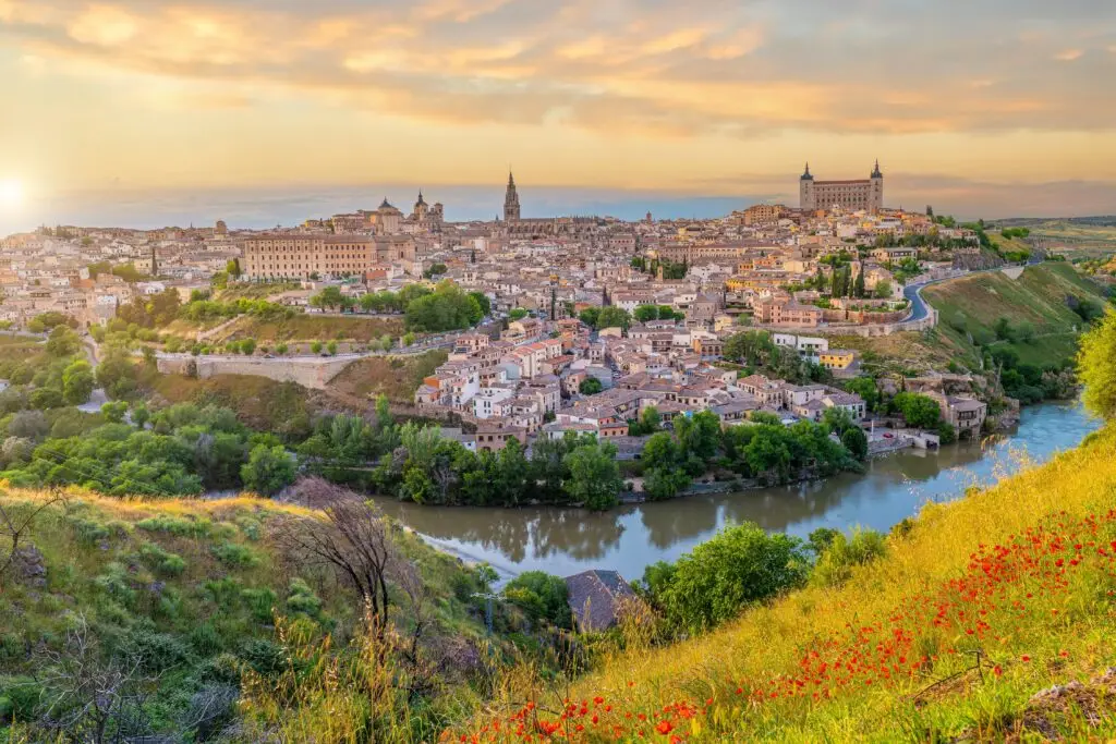 Panoramic view of Toledo Spain with the Tagus River, historic architecture, and the Alcázar at sunset