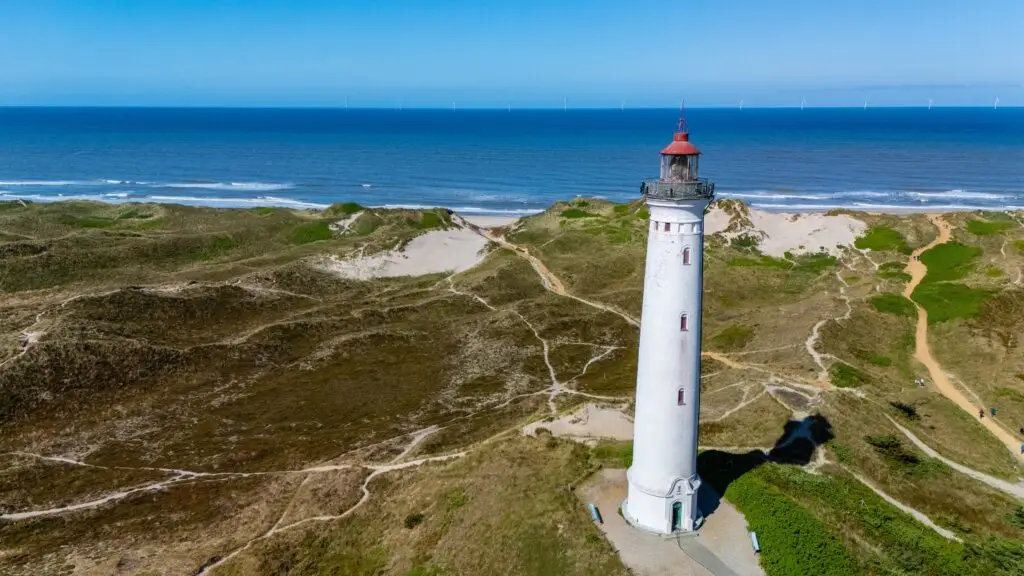 Lyngvig Lighthouse on coastal sand dunes overlooking the North Sea in Denmark, a popular tourist attraction and scenic viewpoint