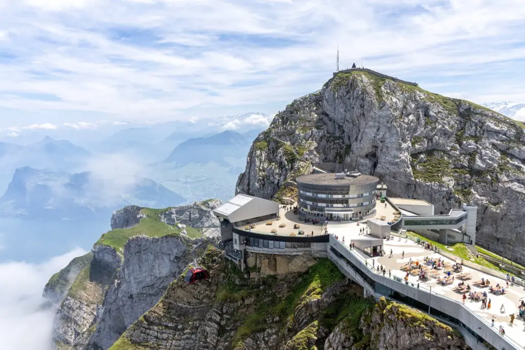 Scenic view of Mount Pilatus in Switzerland with tourists enjoying the observation deck, cable car, and panoramic views of the Swiss Alps and Lake Lucerne