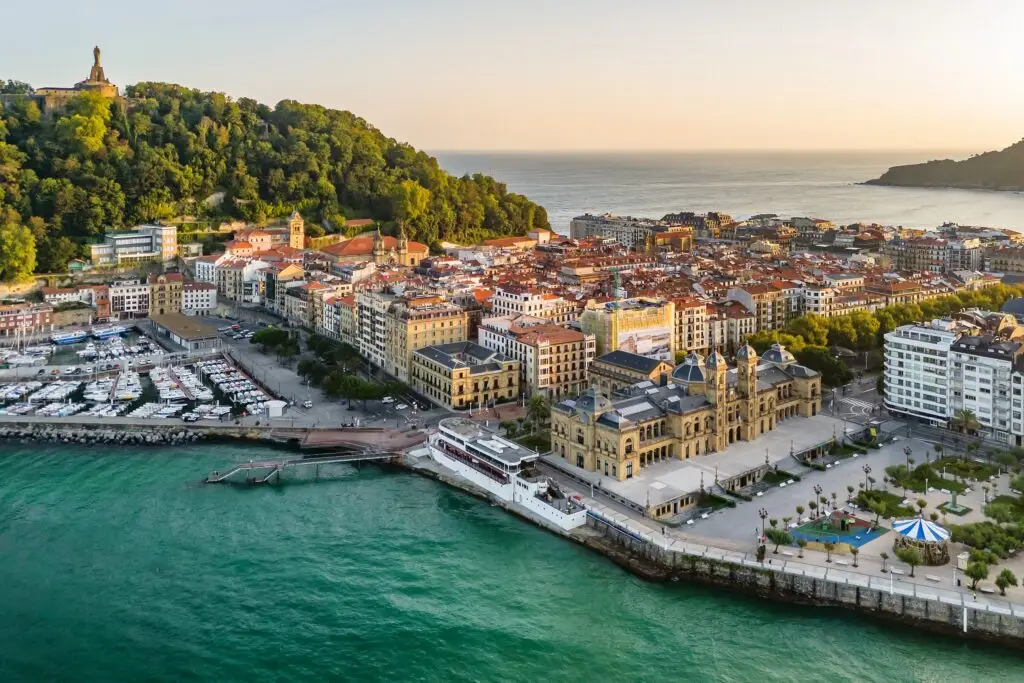 Aerial view of San Sebastian cityscape at sunrise in Spain, showcasing the coastline, marina, and historic architecture perfect for European private tours