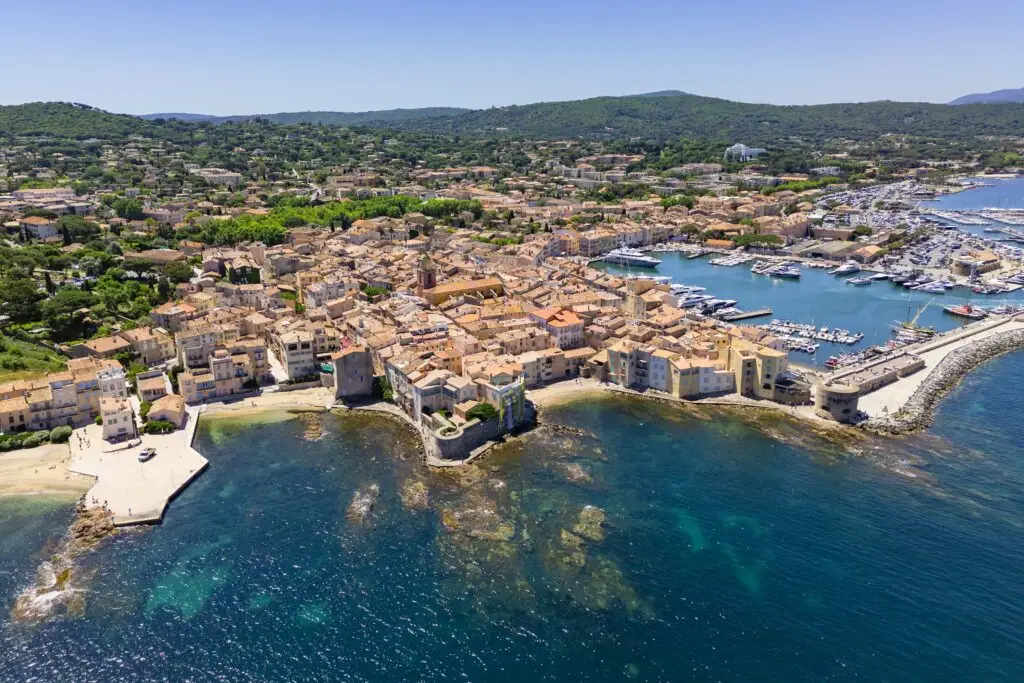 Aerial view of Saint-Tropez France showcasing the old town, marina with yachts, and Mediterranean coastline on a sunny day