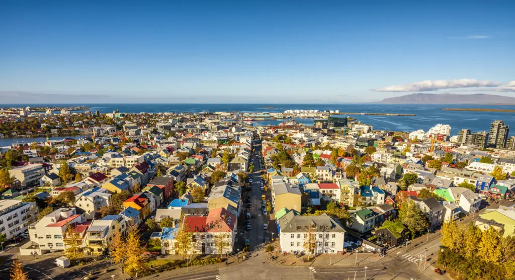 Aerial view of downtown Reykjavik Iceland with colorful houses, harbor, and coastal landscape on a sunny day