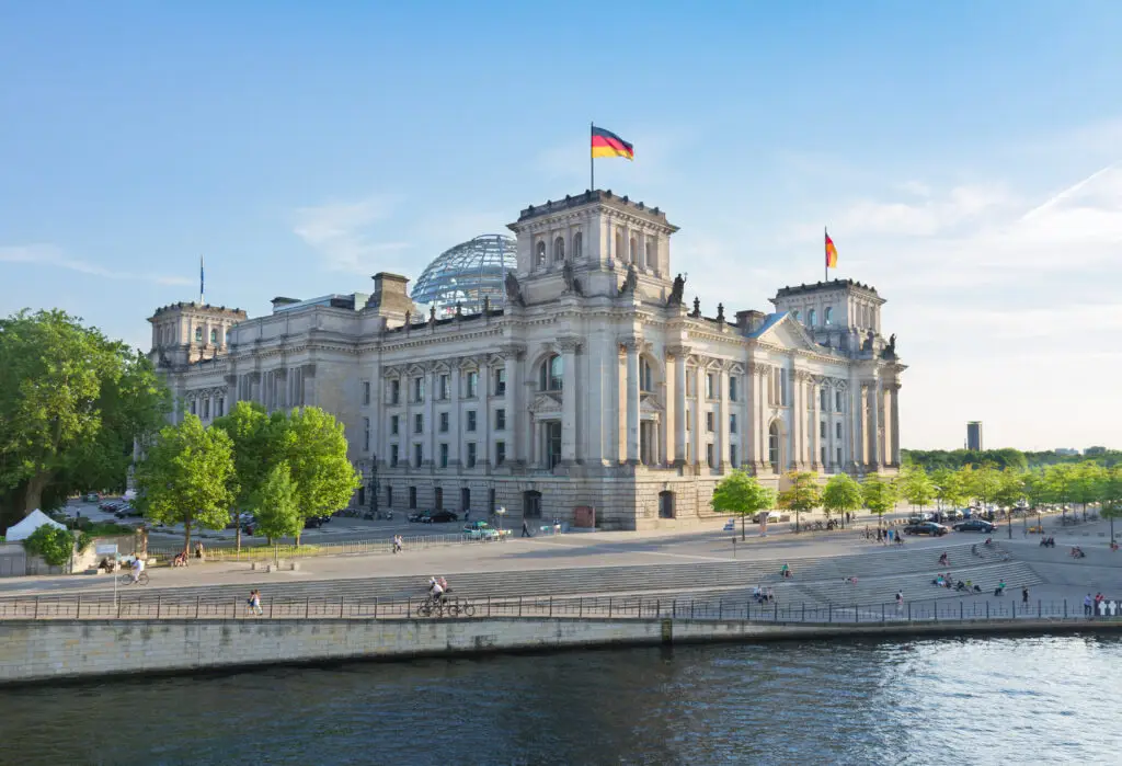 Reichstag Building in Berlin Germany with glass dome and German flag, popular historical landmark and tourist attraction on private tours of Germany