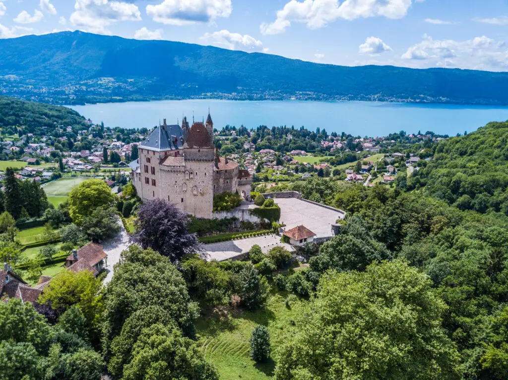 Aerial view of Château d’Annecy overlooking Lake Annecy and the surrounding Alpine landscape in Annecy, France, a popular destination for European private tours and cultural sightseeing.